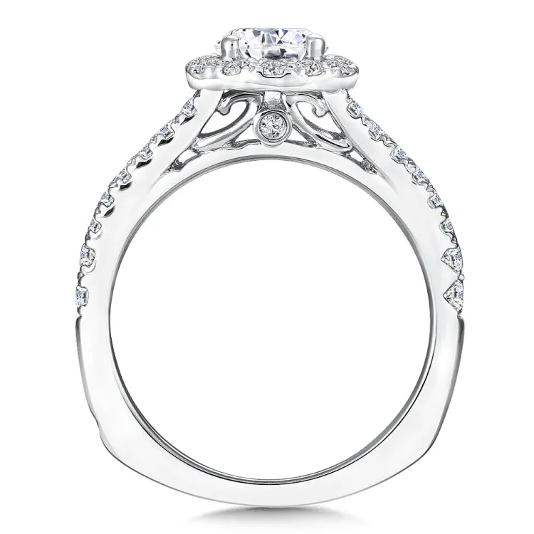 A delicate diamond split shoulder supports a dazzling round center stone in this classic halo design.